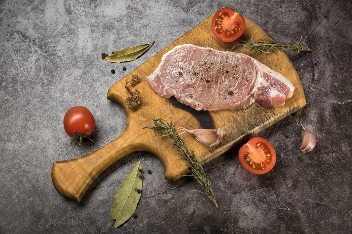 Stock photo of an uncooked pork cut on a wooden board